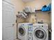 Convenient laundry room with washer, dryer, and shelving at 1054 Sunny Field Ln, Lawrenceville, GA 30043