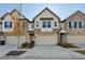 Three-story townhome with brick and siding exterior, attached garage, and landscaping at 1124 Lossie Ln, Grayson, GA 30017