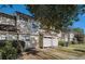 Tan siding townhouses with walkway, landscaping, and partial street view at 3273 Tennington Pl, Lawrenceville, GA 30044