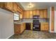 Kitchen with wood cabinets, black appliances, and tile floor at 631 Church Nw St, Atlanta, GA 30318