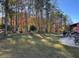 Large backyard with lush lawn, trees, and a patio area at 3829 Reece Farms Ct, Powder Springs, GA 30127