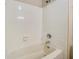 White bathtub with tiled surround and shower fixture at 5267 Tasman Trl, Lithonia, GA 30038