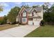 Two-story house with a large driveway and attached garage, surrounded by trees at 2984 Winterthur Close Nw, Kennesaw, GA 30144