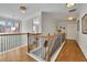 Upstairs hallway with hardwood floors, open railing, and natural light at 3670 Falling Leaf Ln, Cumming, GA 30041