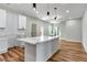 Modern kitchen with white cabinets, quartz countertops and large island at 1510 Olympian Sw Way, Atlanta, GA 30310