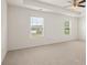 Well-lit bedroom featuring carpet flooring and two large windows at 1463 Autumn Wind Dr, Dacula, GA 30019