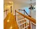 Upstairs hallway with hardwood floors and chandelier at 225 Bayswater Dr, Suwanee, GA 30024