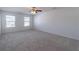 Primary bedroom with ceiling fan, carpet, and two windows at 1829 Redfern Rd, Dacula, GA 30019