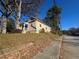 Side view of tan house with street view, trees, and leaves on the ground at 1480 Belmont Sw Ave, Atlanta, GA 30310