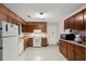 Galley kitchen features wood cabinets, white appliances, and an exterior door at 2616 Landington Nw Way, Duluth, GA 30096