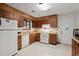 Galley kitchen with wood cabinets, white appliances, and access to backyard at 2616 Landington Nw Way, Duluth, GA 30096