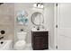 Modern bathroom with a dark vanity, white toilet, and marble-look walls at 4562 Spring St, Acworth, GA 30101