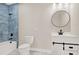 Modern bathroom with blue tile shower, white vanity, and black accents at 4562 Spring St, Acworth, GA 30101