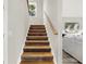 Modern staircase with wooden handrail and dark stained steps at 4562 Spring St, Acworth, GA 30101