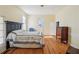 Bedroom with hardwood floors, a queen bed, and a dark headboard at 14299 Highway 36, Covington, GA 30014