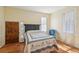 Bright bedroom with hardwood floors, a queen bed, and a wooden door at 14299 Highway 36, Covington, GA 30014