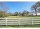 White fence, green lawn, and house in distance at 14299 Highway 36, Covington, GA 30014