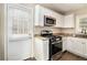 Modern kitchen with white cabinets, granite countertops, and stainless steel appliances at 1425 Cobb Branch Dr, Decatur, GA 30032