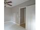 Empty bedroom with white tile flooring, ceiling fan, and open doorway to bathroom at 1584 Tallulah Nw St, Atlanta, GA 30318