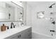 Modern bathroom with gray vanity, marble tile, and a soaking tub at 3645 Aldea Dr, Decatur, GA 30032