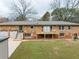 Stone house exterior with a deck, attached garage, and landscaped yard at 3645 Aldea Dr, Decatur, GA 30032
