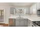 Updated kitchen with gray cabinets, white tile backsplash and stainless steel appliances at 676 Tarkington S Rd, Stone Mountain, GA 30088