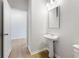 Simple powder room with pedestal sink and hardwood floors at 7065 Brushwood Bnd, Lithonia, GA 30058