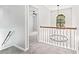 Upstairs hallway with chandelier, carpeted floors, and access to bedrooms at 118 Planterra Way, Peachtree City, GA 30269