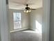 Bedroom with large window, ceiling fan, and grey carpet at 1312 Buttercup Ct, Lawrenceville, GA 30044