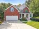 Brick house with a two-car garage and manicured lawn at 1421 Amberton Way, Powder Springs, GA 30127