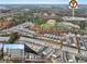 An aerial view showcasing a residential community with townhomes and nearby amenities including a football field at 691 Cordele Ln, Sugar Hill, GA 30518