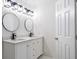 Elegant bathroom with double vanity, modern lighting, and circular mirrors at 2764 Carrie Nw Dr, Kennesaw, GA 30144