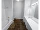 Bathroom features double vanity, shower/tub combo and dark tile floors at 4279 Orchard Grv, Stone Mountain, GA 30083
