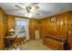 A simply furnished bedroom with wood paneling, ceiling fan, and window at 2948 Lenora Rd, Snellville, GA 30039