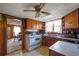Kitchen with wood cabinets, white appliances, and view into the dining area at 2948 Lenora Rd, Snellville, GA 30039