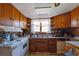 Vintage kitchen with wooden cabinets, white appliances, and double sink at 2948 Lenora Rd, Snellville, GA 30039