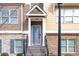 Front entrance with covered porch, gray door, and brick accents at 4192 Integrity Way, Powder Springs, GA 30127