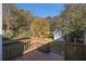 Backyard with wooden deck, green grass, and surrounding trees at 2631 Godfrey Nw Dr, Atlanta, GA 30318