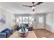 Bright living room with hardwood floors, comfy blue sofa, and ceiling fan at 1729 Creveis Rd, Austell, GA 30168