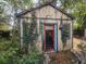 Exterior shed with overgrown vines and a painted door at 43 Gammon Se Ave, Atlanta, GA 30315