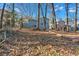 Spacious backyard with mature trees and a partially fenced area at 2080 Bluffton Way, Decatur, GA 30035