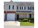 Two-story townhome with a tan exterior, black shutters, and a two-car garage at 45 Eagle Glen Ne Dr, Cartersville, GA 30121