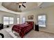 Main bedroom with tray ceiling, ceiling fan, and large windows at 622 Madison Park Dr, Grayson, GA 30017