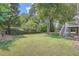 Spacious backyard with lush green grass and mature trees at 2023 Ector Nw Ct, Kennesaw, GA 30152