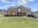 Two story brick home with stone accents, and a lush green lawn at 3045 Pleasant Valley Trl, Cumming, GA 30028