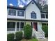 Two story house with white siding, black shutters and a red front door at 1420 Midland Way, Lawrenceville, GA 30043