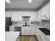 Kitchen features white cabinets, quartz countertops and an island at 1420 Midland Way, Lawrenceville, GA 30043