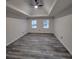 Large main bedroom with tray ceiling, hardwood floors, and two windows at 1420 Midland Way, Lawrenceville, GA 30043