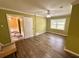 Bright bedroom with wood-look floors, ceiling fan, and access to hallway at 1581 Cheryl Leigh Dr, Riverdale, GA 30296