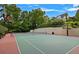 Private tennis court with red and green surface, surrounded by trees at 1154 Ivy Hill Se Ct, Smyrna, GA 30126